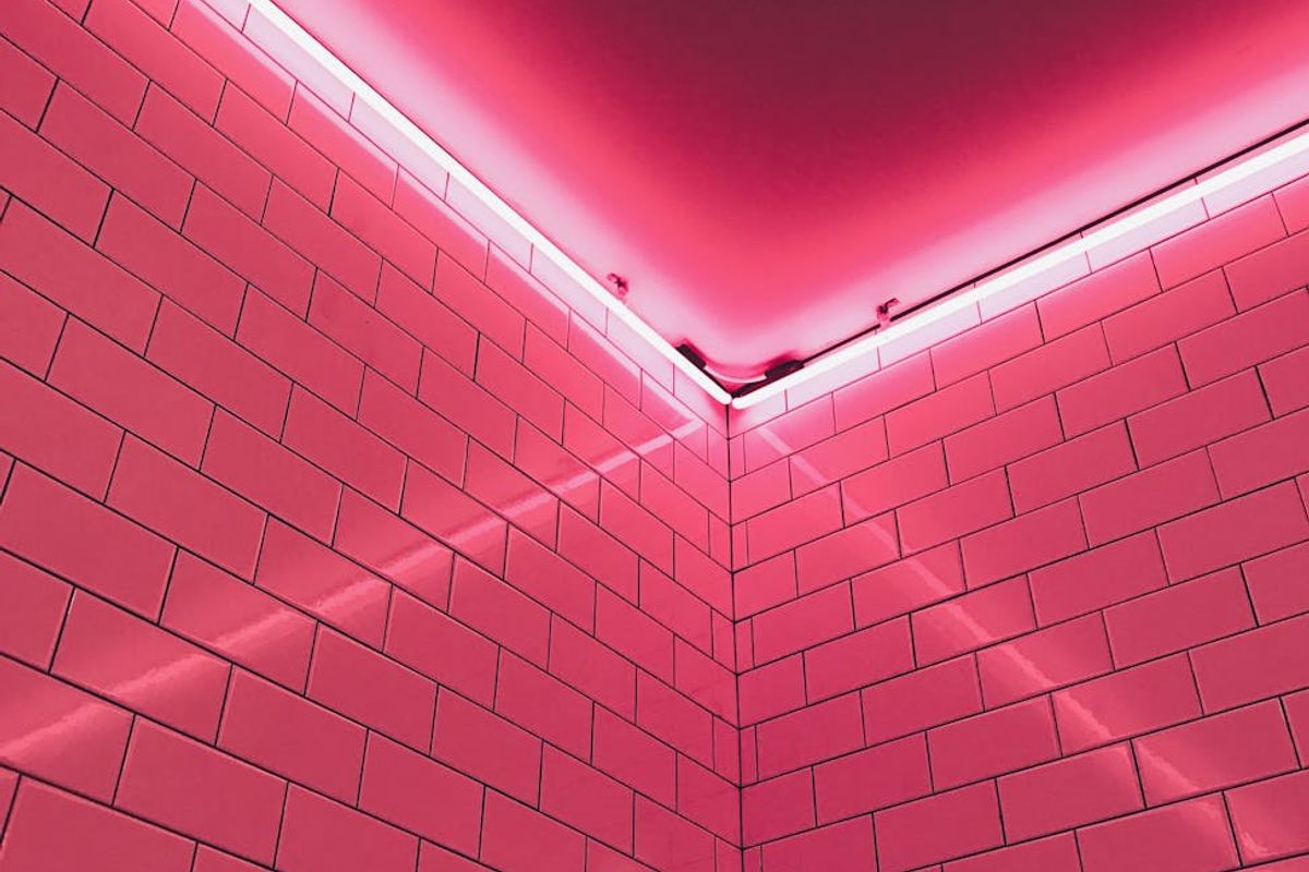 Minimalist yoga room with soft pink neon lighting on the walls.
